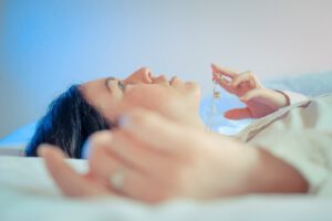 woman lying on bed with her hand on her face