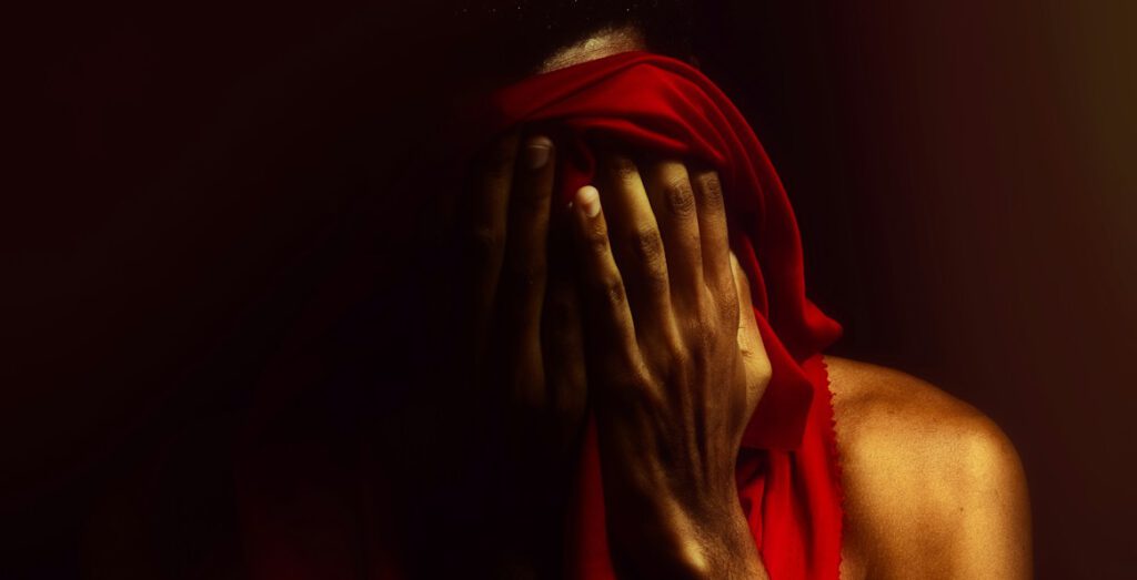 a man covering his face with his hands